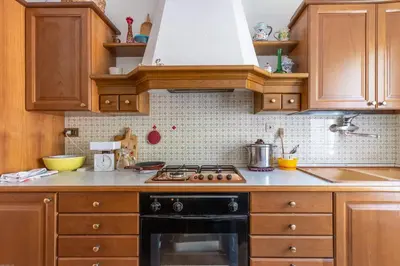 a kitchen with wooden cabinets and a stove top oven at Casa Francesco in Falcade