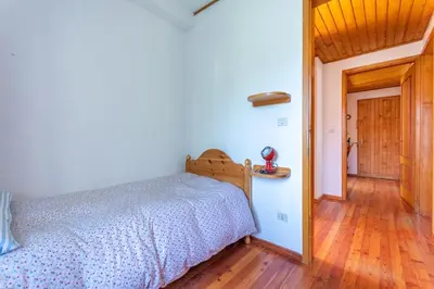 a bedroom with a bed and a wooden floor at Casa Francesco in Falcade