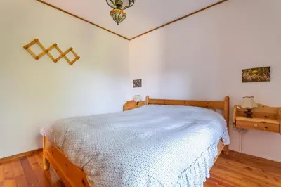a bedroom with a bed with a white bedspread at Casa Francesco in Falcade