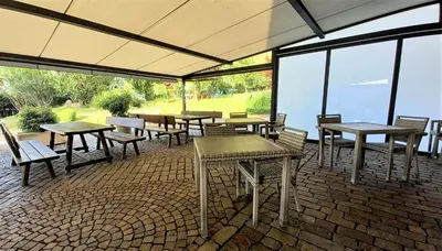 a group of tables and benches on a patio at Hotel Garni Grüner Baum (Albero Verde) in Laives