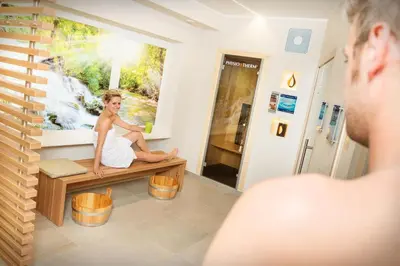 a woman sitting on a bench in a room at Hotel Garni Grüner Baum (Albero Verde) in Laives