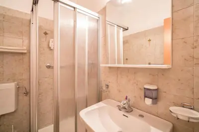 a bathroom with a sink and a shower at Hotel Garni Grüner Baum (Albero Verde) in Laives