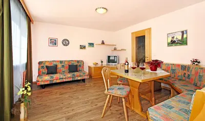 a living room with a table and a couch at Wurzerhof Ratschings, ruhige Ferienwohnungen am Bauernhof mit Bergblick nahe Wander- & Skigebiet in Racines
