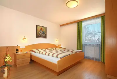 a bedroom with a large bed and a window at Wurzerhof Ratschings, ruhige Ferienwohnungen am Bauernhof mit Bergblick nahe Wander- & Skigebiet in Racines