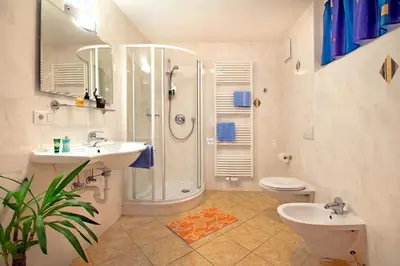 a bathroom with a shower and two sinks and a toilet at Wurzerhof Ratschings, ruhige Ferienwohnungen am Bauernhof mit Bergblick nahe Wander- & Skigebiet in Racines