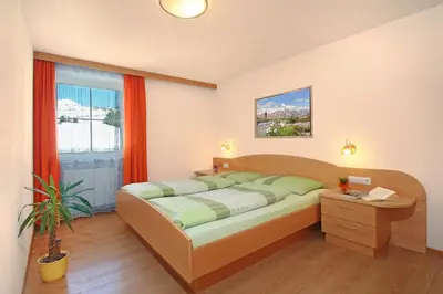 a bedroom with a bed and a window at Wurzerhof Ratschings, ruhige Ferienwohnungen am Bauernhof mit Bergblick nahe Wander- & Skigebiet in Racines