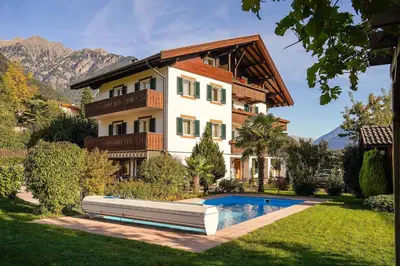 a house with a swimming pool in front of it at Ferienwohungen Gamper in Tirolo