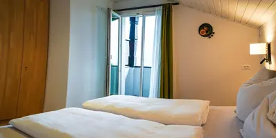 a hotel room with a bed with a window at Ferienwohungen Gamper in Tirolo