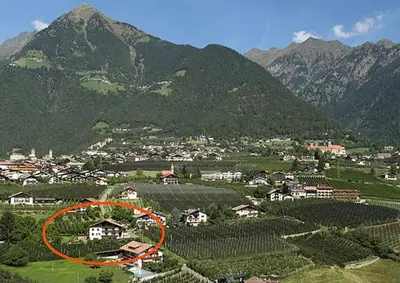 a house in the middle of a field with mountains at Ferienwohungen Gamper in Tirolo