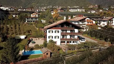 a large white house on a hill with houses at Ferienwohungen Gamper in Tirolo