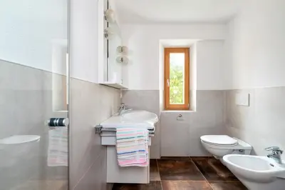 a white bathroom with a sink and a toilet at Apartments San Vigilio in San Vigilio Di Marebbe