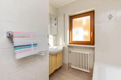 a white bathroom with a sink and a window at Apartments San Vigilio in San Vigilio Di Marebbe