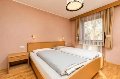 a bed in a room with a window and a bed sidx sidx sidx at Apartments San Vigilio in San Vigilio Di Marebbe