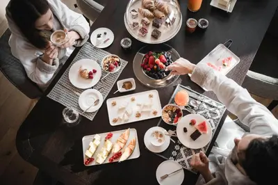 a group of people sitting around a table with food at Luxury Chalet Alpurio in Selva di Val Gardena