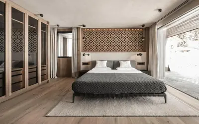 a bedroom with a bed and a large window at Luxury Chalet Alpurio in Selva di Val Gardena