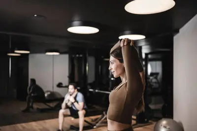 a woman standing in a gym with her arm up at Luxury Chalet Alpurio in Selva di Val Gardena