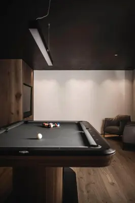 a pool table in a living room with afits at Luxury Chalet Alpurio in Selva di Val Gardena