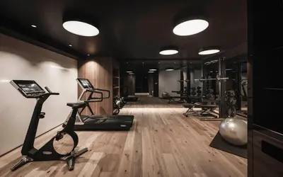a gym with several treadmills and elliptical machines at Luxury Chalet Alpurio in Selva di Val Gardena