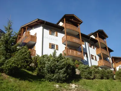 a large white building with wooden balconies at La Odles in Selva di Val Gardena