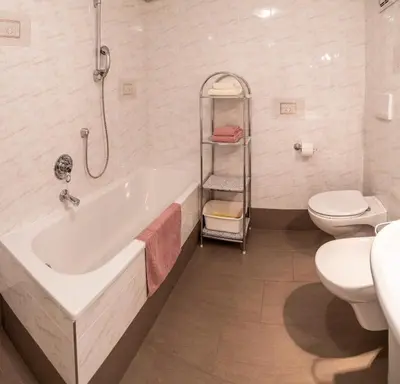 a bathroom with a tub and a toilet and a sink at La Odles in Selva di Val Gardena