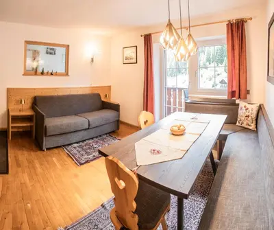 a living room with a table and a couch at La Odles in Selva di Val Gardena