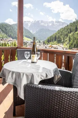 a bottle of wine on a table with two glasses at La Odles in Selva di Val Gardena