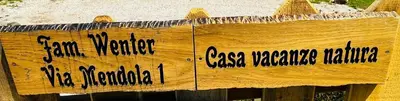 a sign on a wooden fence with writing on it at Casa Vacanze Natura in Mendola