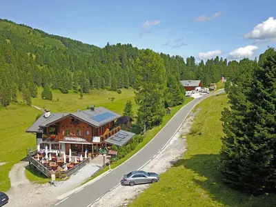 a car parked in front of a house on a road at Edelweißhütte in Funes