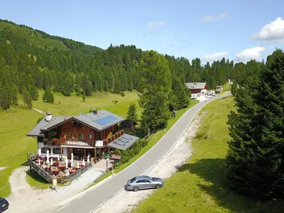 a car parked in front of a building on a road at Edelweißhütte in Funes