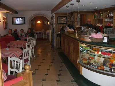 a restaurant with a counter and people sitting at tables at Ciasa Mancin Suite-Apartments in Moena