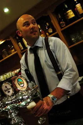 a man standing in a bar with a tie at Ciasa Mancin Suite-Apartments in Moena