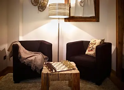a living room with two chairs and a chessboard on a table at Ciasa Mancin Suite-Apartments in Moena