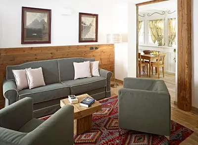 a living room with a couch and two chairs and a table at Ciasa Mancin Suite-Apartments in Moena
