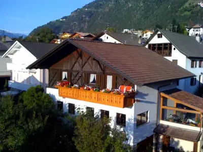 a white house with a brown roof with a balcony at Ferienwohnungen Schweitzer in Parcines