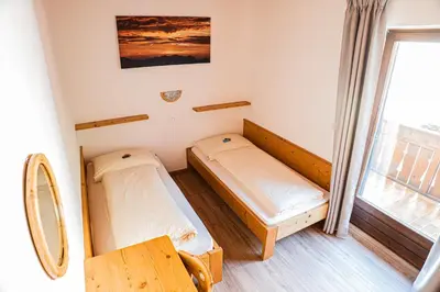 a small room with two beds and a window at Ferienwohnungen Schweitzer in Parcines