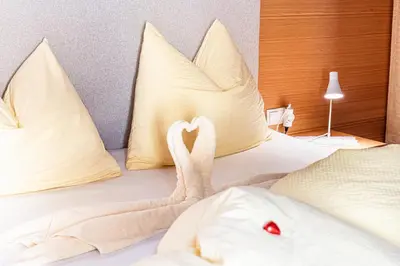 a bed with two swans made out of pillows at Ferienwohnungen Schweitzer in Parcines