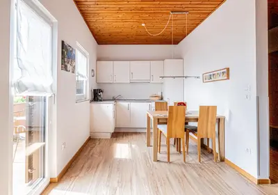 a kitchen and dining room with a table and chairs at Ferienwohnungen Schweitzer in Parcines