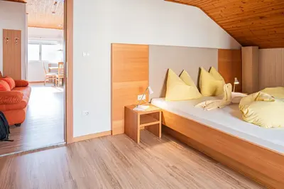 a bedroom with a bed with yellow pillows on it at Ferienwohnungen Schweitzer in Parcines