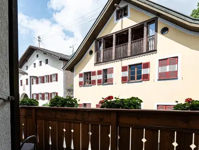 a house with balconies and flowers on a fence at Ferienwohnungen Schweitzer in Parcines