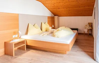 a bedroom with a bed and a desk with a lamp at Ferienwohnungen Schweitzer in Parcines