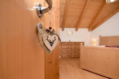 a heart hanging on a door in a room at Aurturist Monguelfo Roulette in Monguelfo