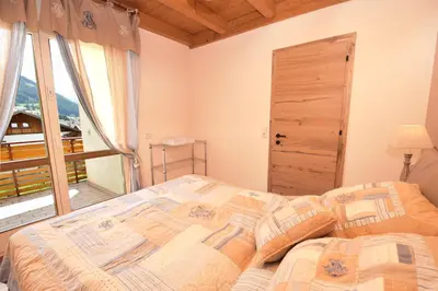 a bedroom with a bed and a large window at Aurturist Monguelfo Roulette in Monguelfo
