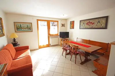 a living room with a couch and a chair and a television at Aurturist Monguelfo Roulette in Monguelfo