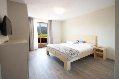a bedroom with a bed and a television in it at Aurturist Monguelfo Roulette in Monguelfo