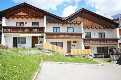 a large white house with wooden balconies on it at Aurturist Monguelfo Roulette in Monguelfo