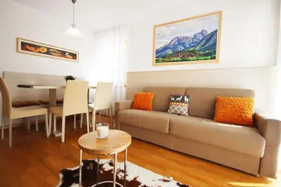 a living room with a couch and a table at Aurturist Villabassa in Villabassa
