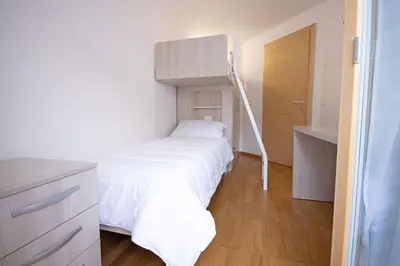 a bedroom with a bed with a ladder in it at Aurturist Villabassa in Villabassa