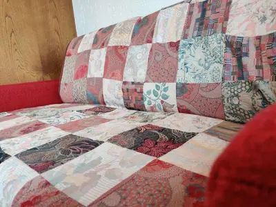 a quilt on the back of a couch at Lärchenheim in Obereggen