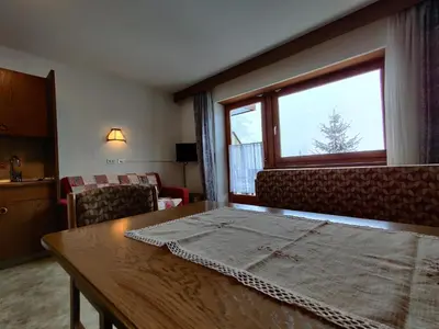 a living room with a table and a window at Lärchenheim in Obereggen