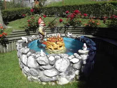 a small pond with a statue of a cat in it at Hotel L'Ideale in Moena